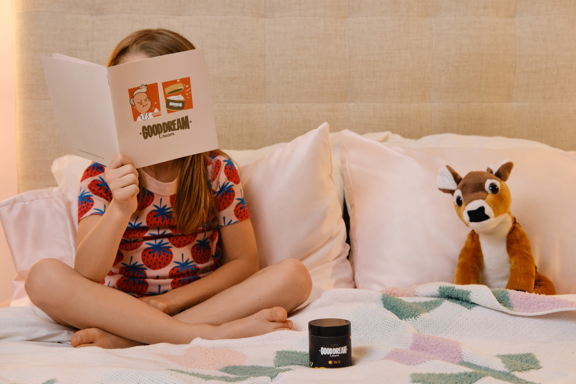 A child on a bed reading the Good Dream Cream™ brochure